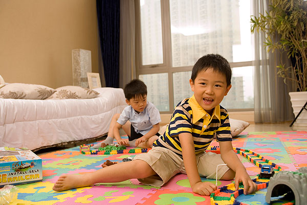 两个小男孩在地板上玩玩具