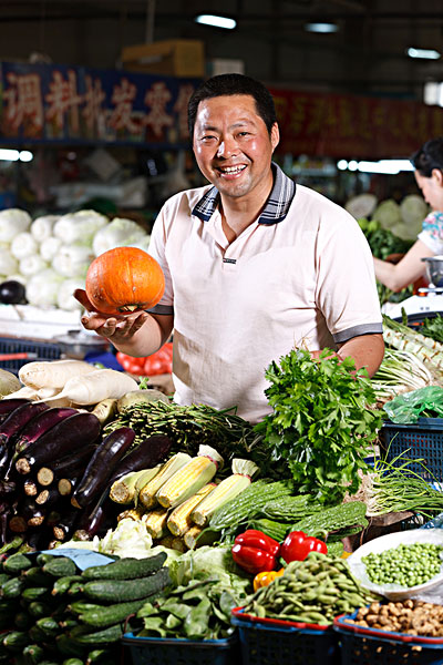 一个菜农在菜市场里卖菜