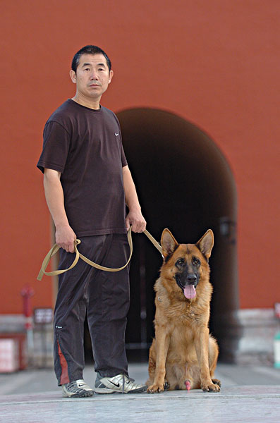 一个人牵着狗在故宫城门前
