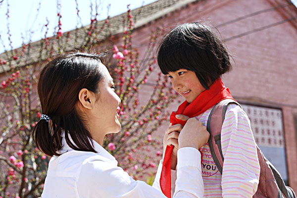乡村老师给小学生戴红领巾